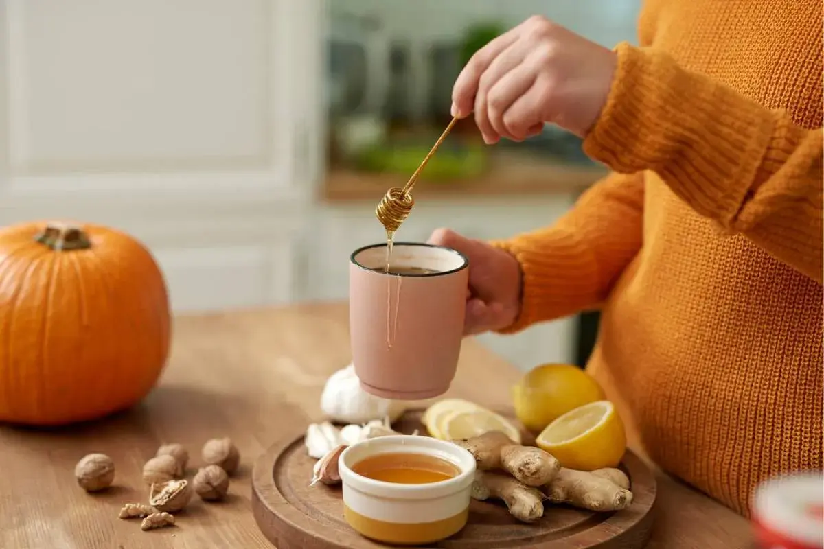ریختن عسل طبیعی در آب جوش و لیمو ترش تازه برای تسکین سوزش گلو.